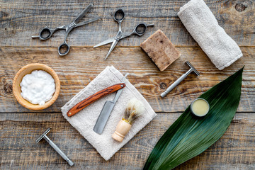 Barber workplace. Shaving brush, razor, foam, sciccors on wooden table background top view