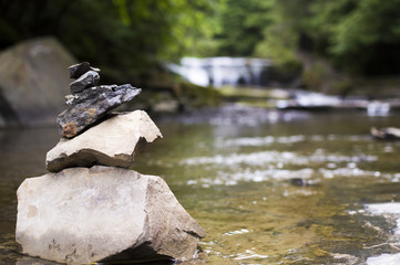 Stacked stones as a close-up with a waterfall in the background