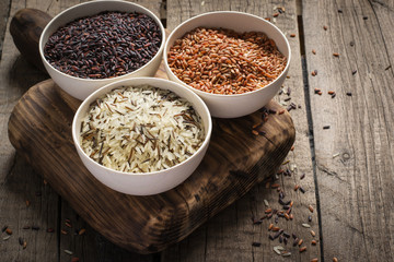 collection of different varieties of rice on wooden rustic background
