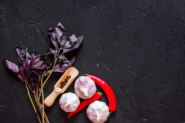 Cook workplace. Peper, garlic, basil on black table background top view copyspace