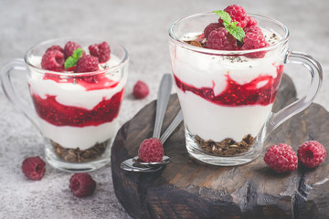 Raspberry healthy dessert or breakfast with natural yogurt in glass mugs