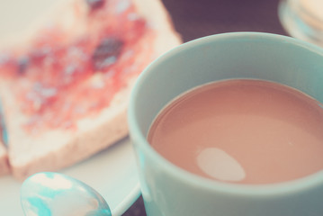 Plate with slices of bread with butter and strawberry jam and cogee for breakfast closeup photo