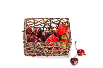 isolated strawberry and cherry in bamboo basket