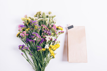 Bouquet of multicolored wildflowers and a package with a gift