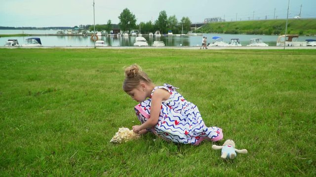 The lovely little girl listens to a big shell to hear noise of waves