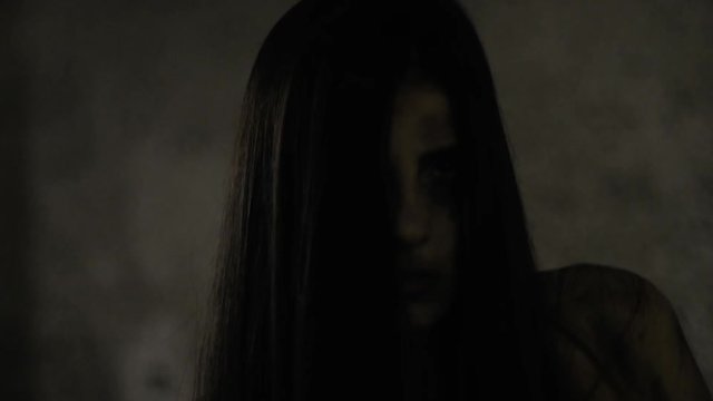 Female zombie attacking and killing man walking in garage slow motion extreme closeup