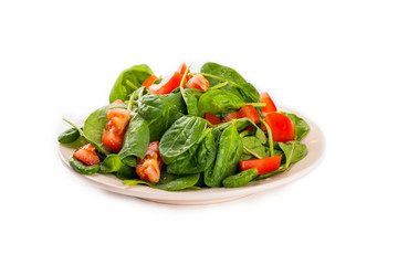 Salad with tomato, cucumber and spinach on the plate isolated on white background