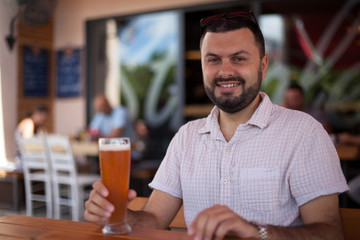 Fototapeta na wymiar Portrait of smiling man drinking a beer