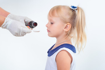 Doctor hand giving spoon dose of medicine liquid drinking syrup to child
