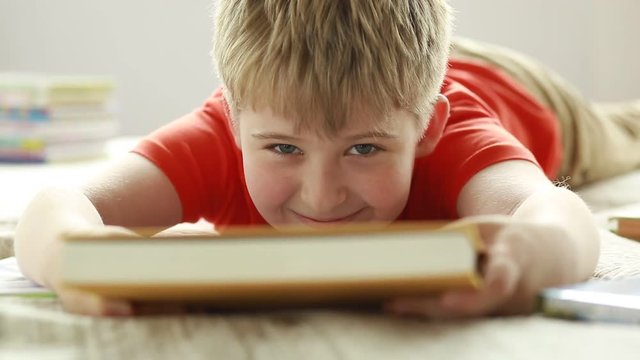 Portrait of a cheerful schoolboy with a book.