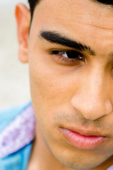 Closeup of a young man's face; part of the face is obscured