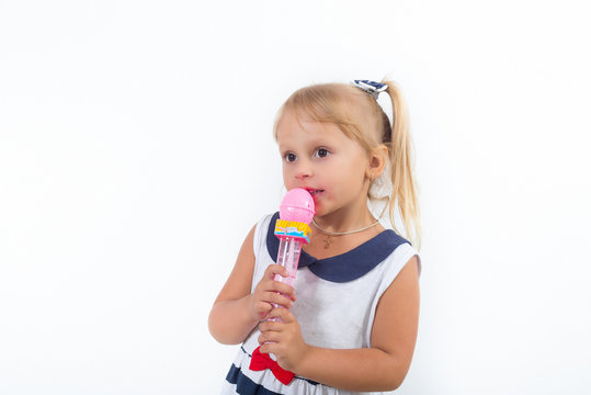 A little girl is singing a cheerful song into the microphone. Happy carefree childhood.