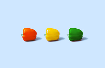 Set of three peppers on the blue background. Yellow, red and green pepper.
