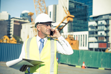 Man architector outdoor at construction area having mobile conve