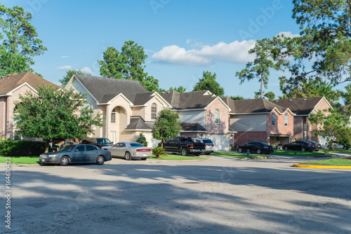 Fototapete Suburban Residential Street With Row Of Modern Townhomes In Humble Texas Us Red Brick Houses Surrounded With Tall Pine Trees And Cloud Blue Sky Corner View Of Multi Story Townhouses Development Trongnguyen