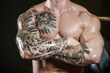 Strong and handsome athletic young tattoo man with muscles