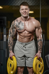 Fototapeta na wymiar Strong and handsome athletic young tattoo man with muscles