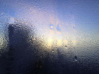 Blurred water drops on wet window abstract background. Close up photography