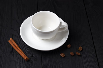 Empty coffee cup with a cinnamon stick on a black background