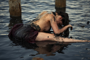 Young woman bathing in therapeutic water of mud estuary.
