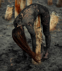 Young woman smeared with therapeutic mud and lies on wooden column.