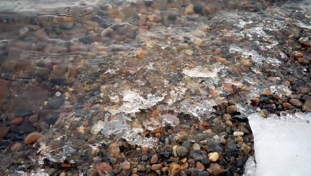Fast shallow river forms the ice pieces on the shore