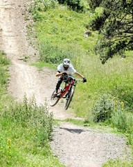 Hombre en bicicleta de montaña bajando por una cuesta en plena competición