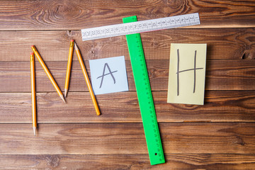 Text math composed of pencils, rulers, circular, sharpener and sticker with the letter