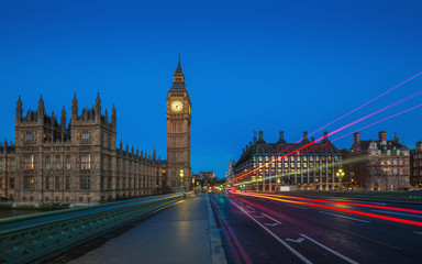 London, England - The famous Big Ben and Houses of Parliament with lights of double decker buses...