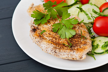 Fried chicken fillet decorated with cherry tomatoes and cucumber.