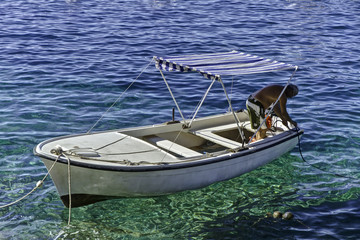 Man preparing small  boat in the calm water of Hvar, Croatia