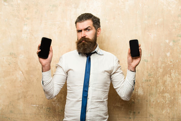 businessman or bearded man compare mobile phone and smartphone