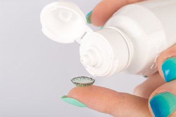 Contact lens, case and bottle of solution close-up