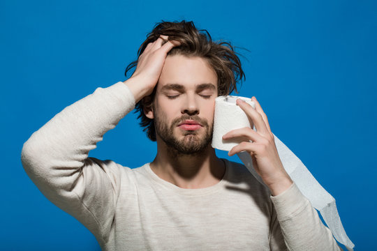 man with closed eyes and sleepy face hold toilet paper