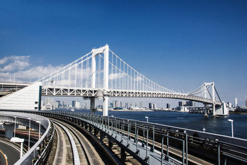 Railway bridge construction in Tokyo with blue sky in the background. 