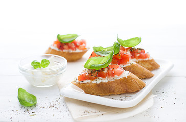 Bruschetta with cream cheese, tomatoes and basil