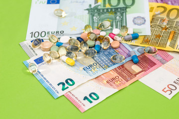 many pills and euro bankontes on green background