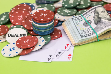 Poker chips and play card with dollar on green
