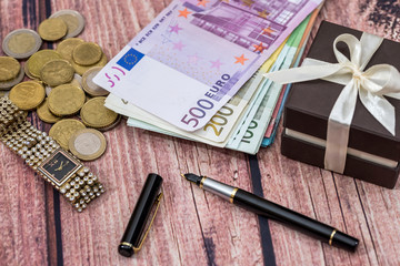 birthday concept - gift box, euro banknote and coin, clock, pen