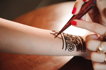 Drawing process of henna menhdi ornament on woman's hand