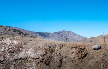 People mountain biking down race on track trail in the Sierra Nevada Mountains in Spain on a sunny day.