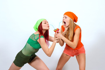 Two young girls hold an imaginary cocktail in their hands. They fight it out to see who gets to...