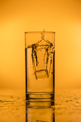 Splash of falling ice in a glass with water