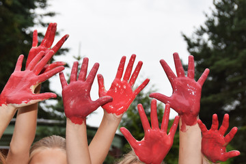 red hands of children playing staining