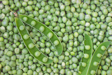 Naklejka na ściany i meble Green peas and pea pod closeup. Top view. Food background.