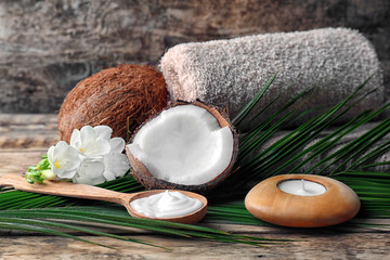 Composition with coconut cream in spoon for spa treatment on wooden background