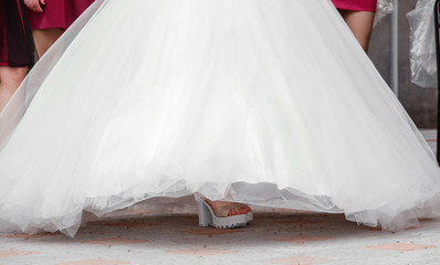 Bride dresses shoes.  bride's shoes with long legs in white wedding dress.