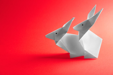 Origami rabbits on color background. Sex concept