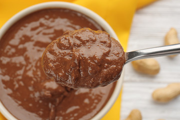 Spoon with creamy peanut butter, closeup