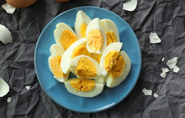Plate with hard boiled sliced eggs on table. Nutrition concept